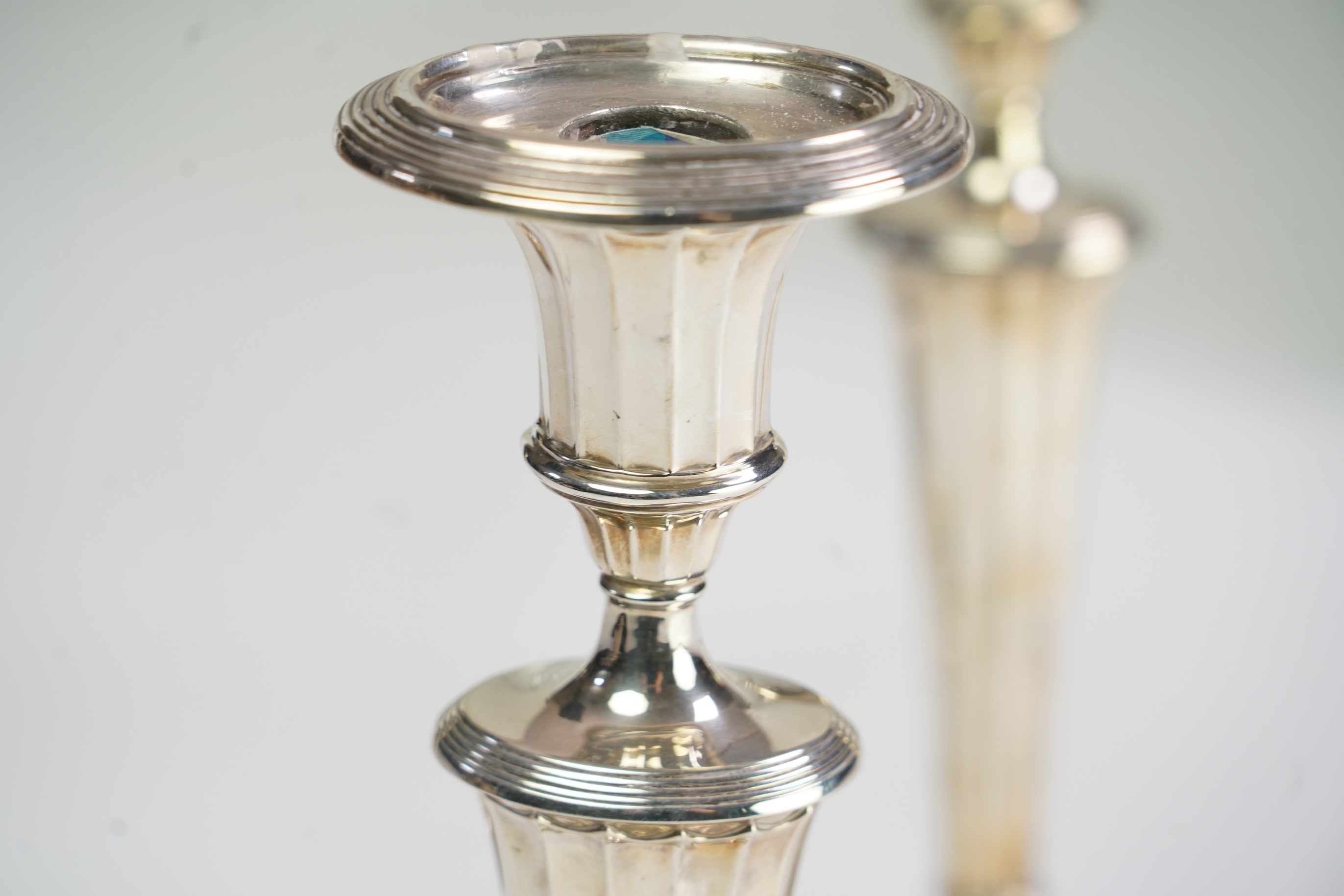 A matched set of four Edwardian fluted silver candlesticks, by Sibray, Hall & Co Ltd